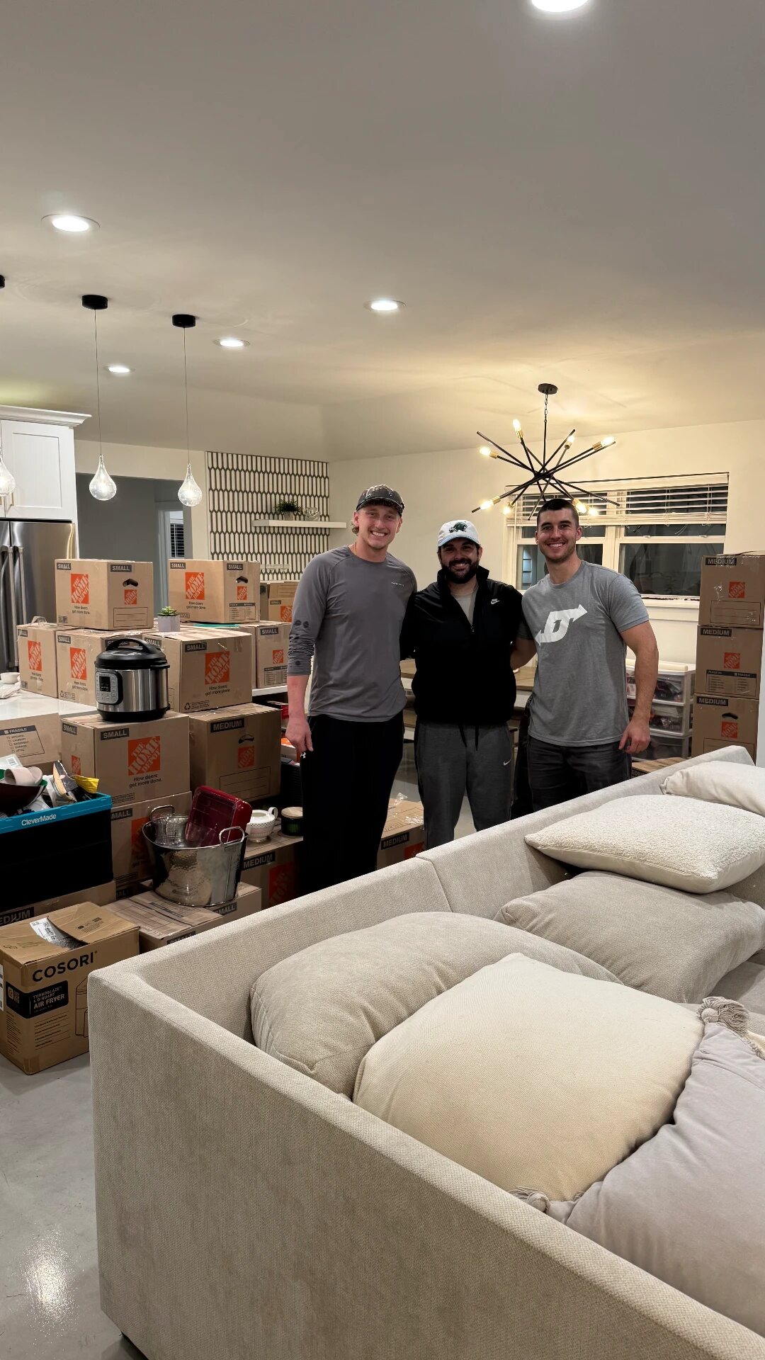 D1 movers standing with packed boxes and furniture inside a home
