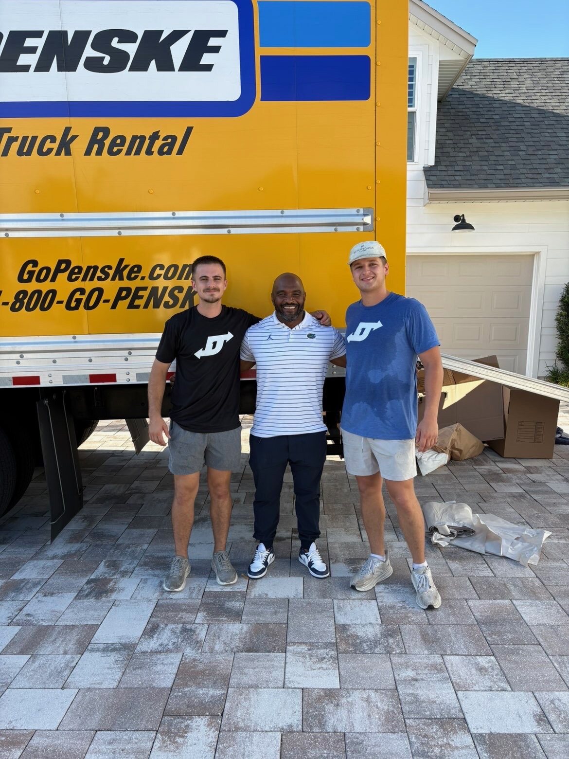 D1 Moving & Logistics crew members with a customer beside a loaded moving truck