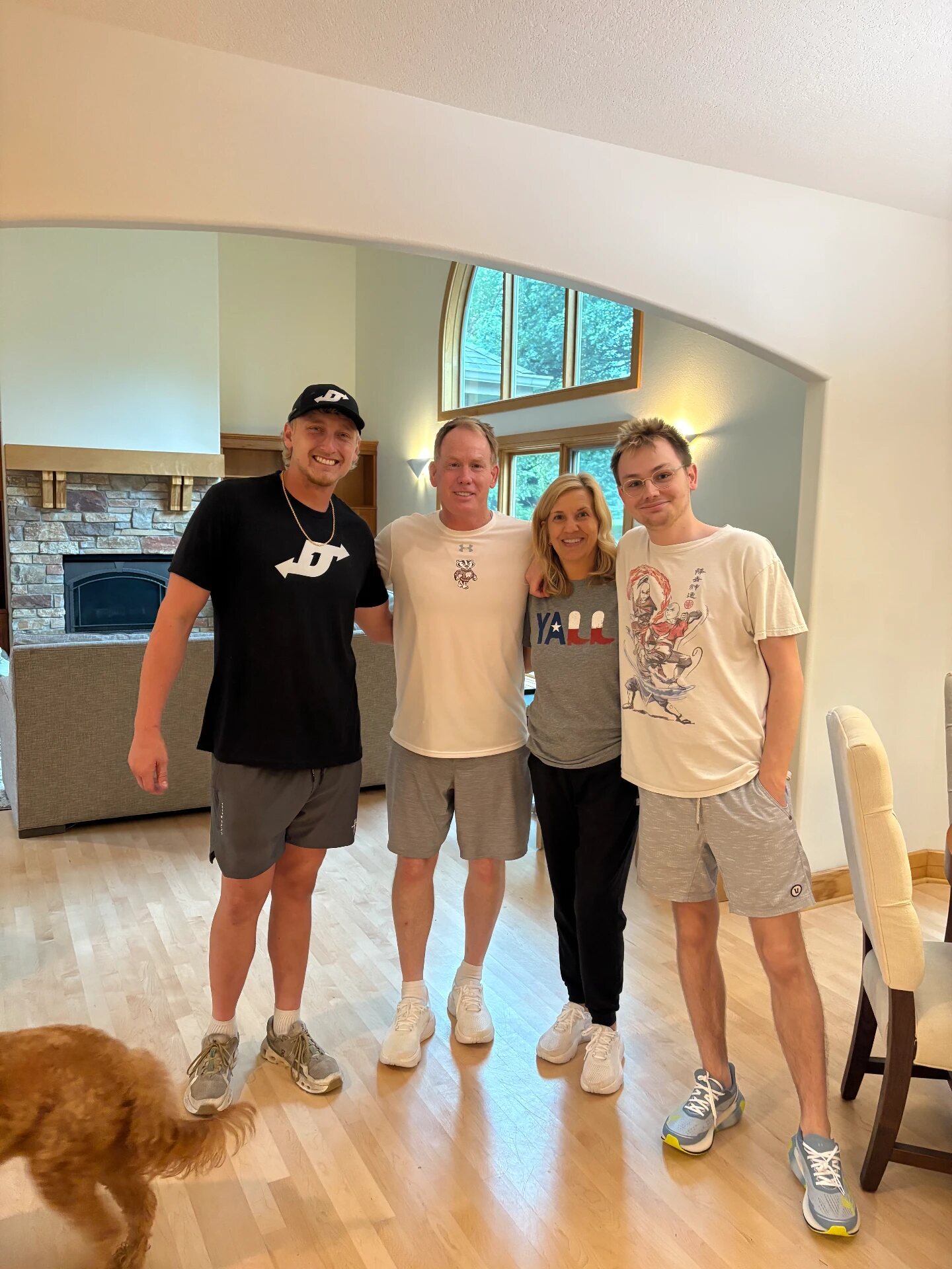 A family standing in the doorway of their new home surrounded by moving boxes